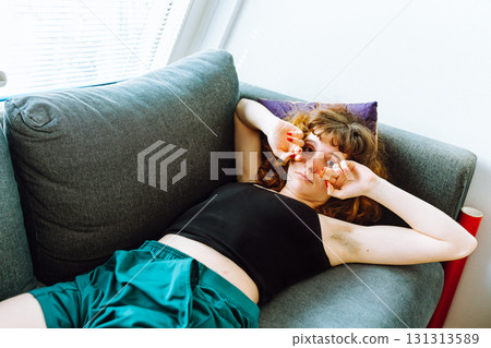 young red-haired woman tired lies on sofa young red-haired woman tired lies on sofa 131313589
