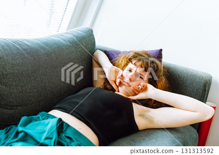 young red-haired woman tired lies on sofa young red-haired woman tired lies on sofa 131313592