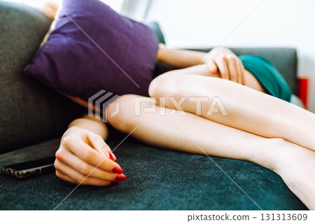 young red-haired woman tired lies on sofa 131313609