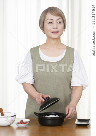 Senior woman making rice balls in the kitchen 131314614
