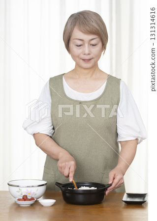 Senior woman making rice balls in the kitchen 131314616