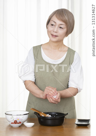 Senior woman making rice balls in the kitchen 131314627