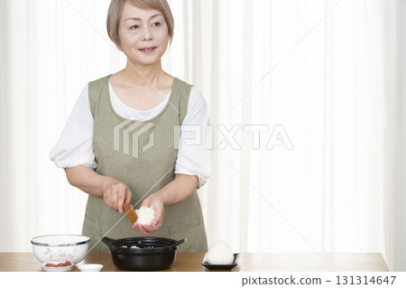 Senior woman making rice balls in the kitchen 131314647