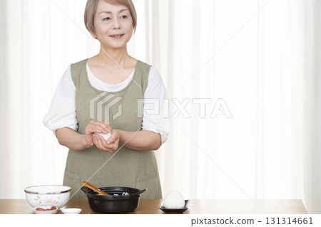 Senior woman making rice balls in the kitchen 131314661