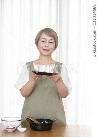 Senior woman making rice balls in the kitchen Senior woman making rice balls in the kitchen 131314666
