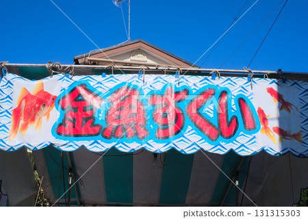 Goldfish scooping stall sign and blue sky Goldfish scooping stall sign and blue sky 131315303