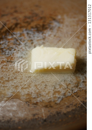 Butter melting on a warm skillet during cooking session Butter melting on a warm skillet during cooking session 131317012