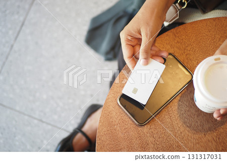 Person making contactless payment at a cafe table Person making contactless payment at a cafe table 131317031