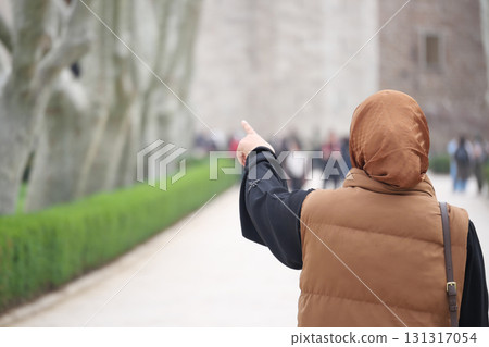 Person pointing towards a distant landmark in a park setting Person pointing towards a distant landmark in a park setting 131317054