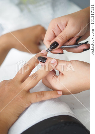 Woman receiving manicure in a beauty salon Woman receiving manicure in a beauty salon 131317131