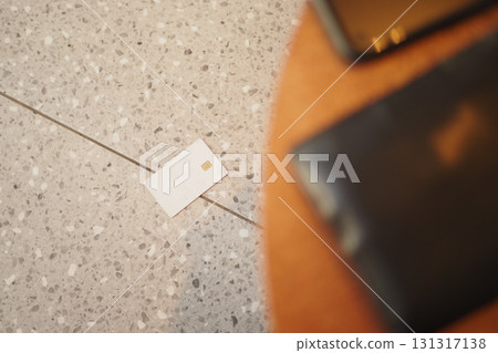 Card on the floor near a smartphone and wallet 131317138