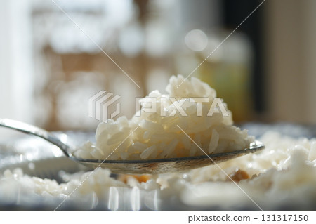 Delicious white rice served on a spoon in bright sunlight Delicious white rice served on a spoon in bright sunlight 131317150