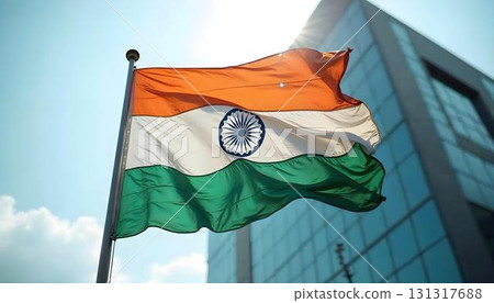 The Indian flag billows in front of a building, commemorating Independence Day with a celebratory background 131317688