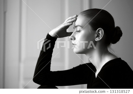 Thoughtful Woman Touches Her Forehead in a Black and White Setting at Home Thoughtful Woman Touches Her Forehead in a Black and White Setting at Home 131318527