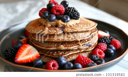 A stack of fluffy buckwheat pancakes with a generous dollop of almond butter and fresh berries 131319581