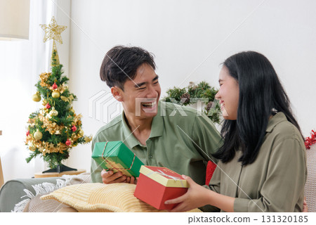 Christmas happy couple share love, exchange holiday winter gifts, celebrating festive home, creating warm christmas memories, enjoying special joyful moment. 131320185