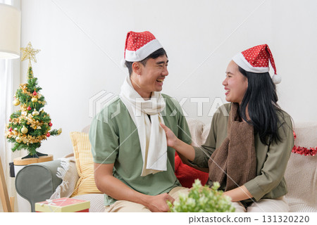 Christmas celebration, happy couple shares love, winter holiday atmosphere, enjoying home comfort, exchanging pleasantries, bright festive spirit, warm christmas joy. 131320220