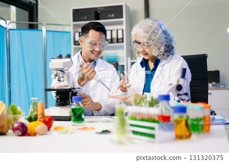 Team Asian scientists in a lab conducting food research using a microscope and lab equipment, showcasing innovation Team Asian scientists in a lab conducting food research using a microscope and lab equipment, showcasing innovation 131320375