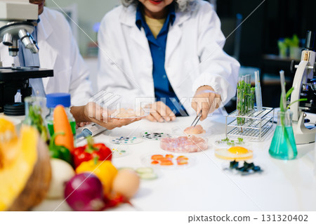 Team Asian scientists in a lab conducting food research using a microscope and lab equipment, showcasing innovation 131320402