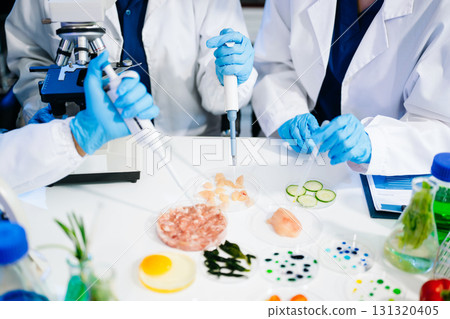 Food scientists in lab coats, testing samples, and analyzing food safety and quality in a modern laboratory 131320405