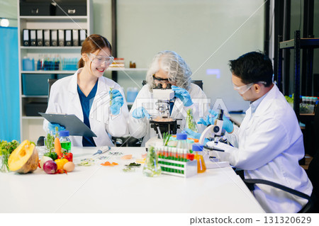 Food scientists in lab coats, testing samples, and analyzing food safety and quality in a modern laboratory 131320629