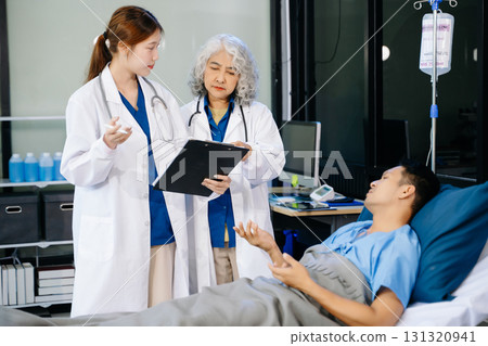 Hospital Ward Male and Male Professional Asian Doctors Talk with a Patient, Give Health Care Advice, Hospital Ward Male and Male Professional Asian Doctors Talk with a Patient, Give Health Care Advice, 131320941