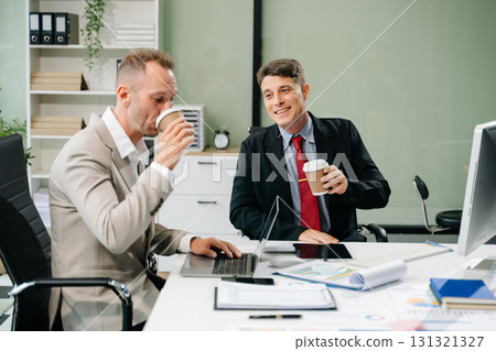 Professionals brainstorming and analyzing charts during a business meeting. Highlighting teamwork, Professionals brainstorming and analyzing charts during a business meeting. Highlighting teamwork, 131321327