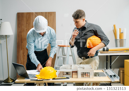 Architects and engineers collaborating on blueprints and models, showcasing teamwork, planning 131321513