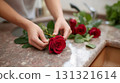 Woman arranging a bouquet of fresh red roses in a kitchen 131321614