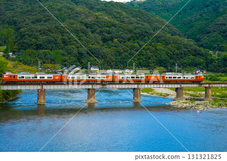 Express train Yakumo 1 bound for Okayama Station crossing the Second Takahashi River Bridge in early autumn, Takahashi City, Okayama Prefecture 131321825