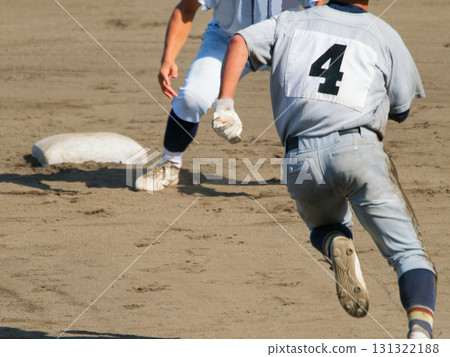 A player striving to reach second base and another player preparing to touch base in a high school baseball game 131322188
