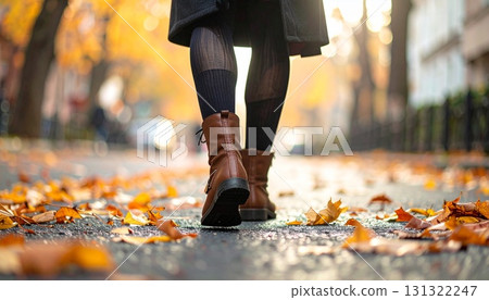 街角被落葉包圍的深色緊身褲和棕色靴子的低角度視圖 131322247