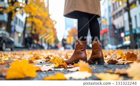 街角被落葉包圍的深色緊身褲和棕色靴子的低角度視圖 街角被落葉包圍的深色緊身褲和棕色靴子的低角度視圖 131322248