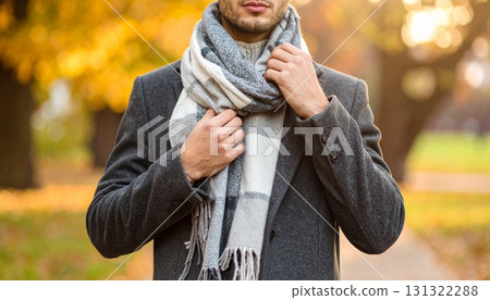 穿著羊毛大衣的中軀幹調整圍巾，秋季公園背景 131322288