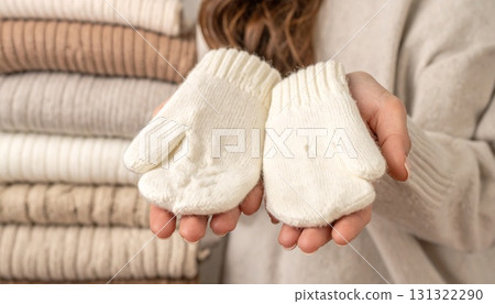 特寫:手上戴著羊毛手套,背景是多層毛衣 特寫:手上戴著羊毛手套,背景是多層毛衣 131322290