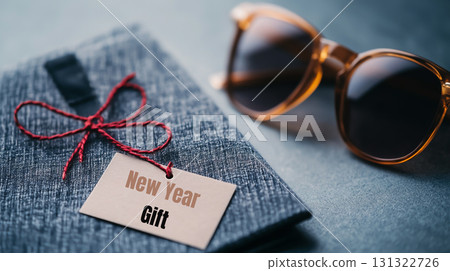 New Year gift with sunglasses on textured surface, perfect for celebrations 131322726