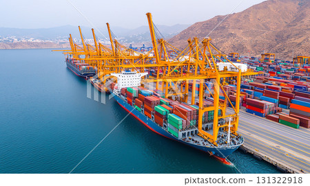 Aerial view of busy port with cranes loading colorful containers 131322918