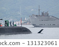 A Taigei-class submarine of the Japan Maritime Self-Defense Force hoisting the Self-Defense Force flag at Kure Base and the transport ship Yohkoh leaving port. 131323061