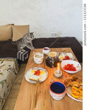 Breakfast table with cat and food Breakfast table with cat and food 131323196