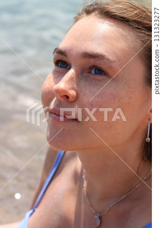 Woman looking upwards near water 131323277
