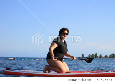 Woman paddleboarding in lake 131323573