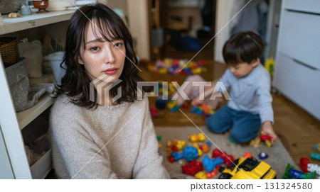 一位表情憂鬱的母親,身後站著一個堆滿玩具的房間,裡面的孩子 一位表情憂鬱的母親,身後站著一個堆滿玩具的房間,裡面的孩子 131324580