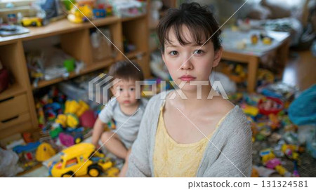 房間裡堆滿了玩具，一位年輕的母親和她的孩子看起來很疲憊 131324581