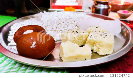 Traditional Indian Sweets and Offerings on a Steel Plate 131324742