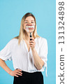 Studio portrait of woman with magnifying glass 131324898