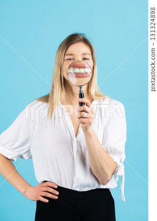 Studio portrait of woman with magnifying glass 131324898