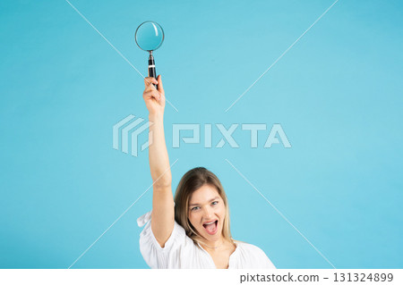 Studio portrait of woman with magnifying glass 131324899