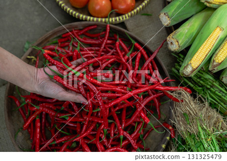 Vibrant Red Chilies and Fresh Vegetables Beautifully Displayed in a Market Setting Vibrant Red Chilies and Fresh Vegetables Beautifully Displayed in a Market Setting 131325479