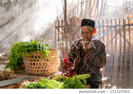 An elderly man surrounded by fresh vegetables and billowing smoke in a serene rural setting An elderly man surrounded by fresh vegetables and billowing smoke in a serene rural setting 131325561