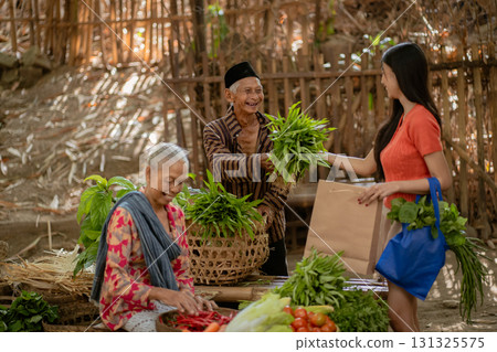 In the local market, vibrant women actively engage in selling an array of fresh vegetables 131325575